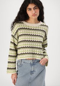 Heklet genser i grønne, beige og brune striper. Strikkemønster med åpen struktur. Kort design, lange ermer og ribbestrikket hals.