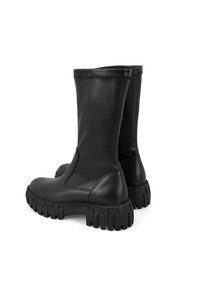 Zwarte leren kniehoge laarzen met een ronde neus en een robuuste rubberen zool. Gladde textuur met minimale stiksels en geen zichtbare hardware.