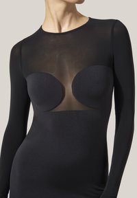 Svart långärmad klänning med genomskinlig toppanel och definierade bystkoppar. Tillverkad av slät, stretchig tyg, den har en figurnära silhuett.