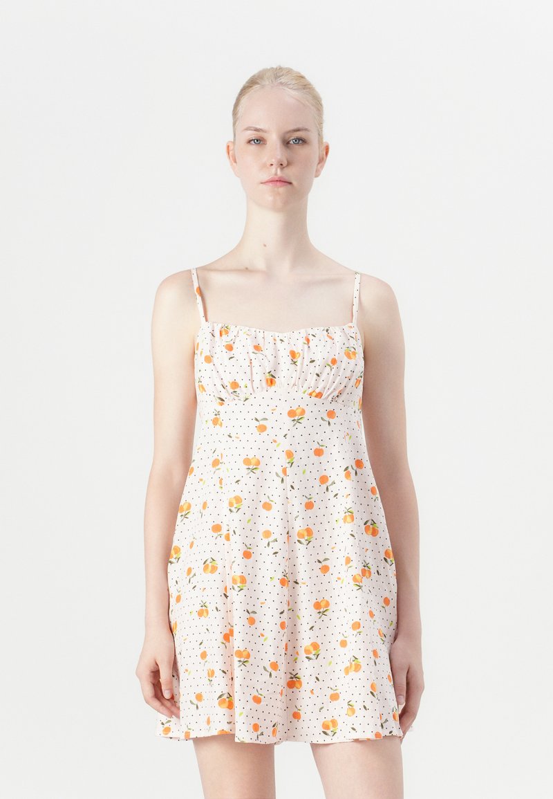 Rochie florala cu fructe portocalii si accente verzi pe un material alb cu buline. Prezinta bretele ajustabile si un corset ajustat.