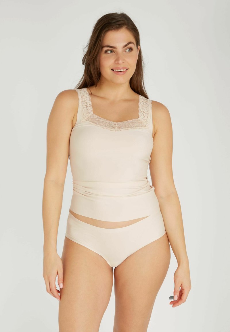 Beige tanktop met kanten rand en hoge naadloze slipjes met uitsnijdingen, gemaakt van een gladde, elastische stof.