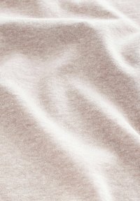 Helle beige Stoff mit einer weichen Textur und einem subtilen gesprenkelten Muster. Das Material scheint gestrickt zu sein und hat einen sanften Fall.