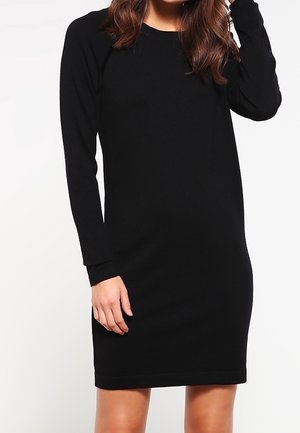 Robe noire à manches longues au design ajusté, en matériau doux, avec un col rond et une longueur juste au-dessus du genou.