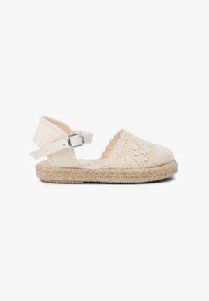 Espadrille tissée blanche avec un bord festonné, bride de cheville ajustable et semelle en jute. Présente une tige en tissu texturé et une semelle en caoutchouc.