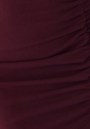 Tissu extensible bourgogne avec une texture froncée, présentant de légères lignes verticales et une surface douce et lisse. Pas de matériel ou d'accents visibles.