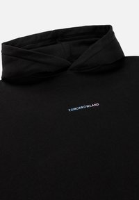 Zwarte hoodie met een zachte textuur. Voorzien van een klein, verloop "TOMORROWLAND" logo op de voorkant in blauw en roze.