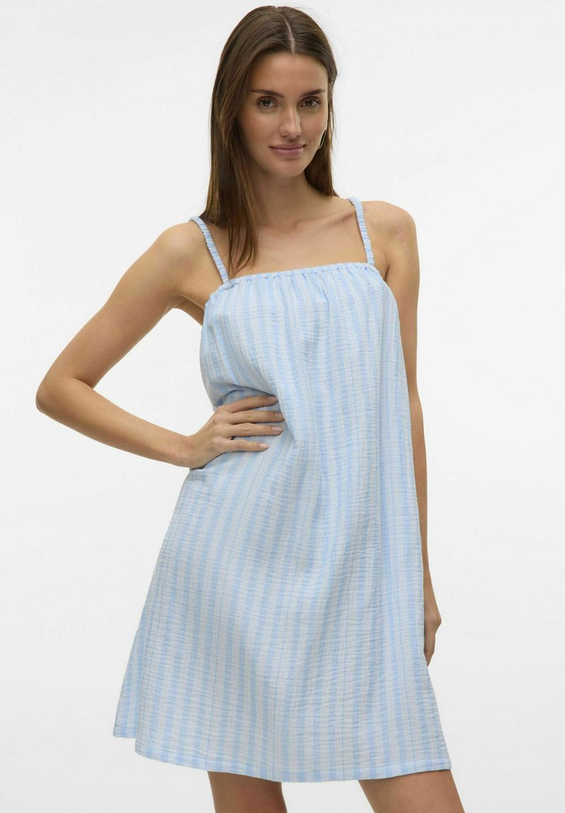 Vestido de verano a rayas en azul claro y blanco, con tirantes finos y un corpete fruncido, que llega hasta mediados del muslo. Está hecho de una tela suave y ligera.