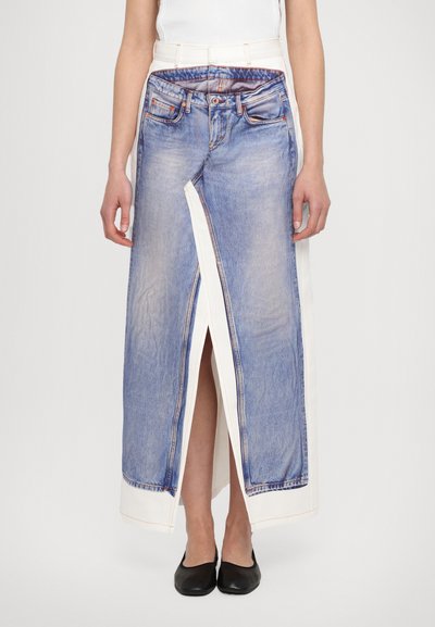 Denim maxi skirt featuring a front slit, combined with a white fabric waistband and contrasting denim detail, offering a unique layered design.