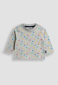 Maglietta a maniche lunghe grigia per bambino con motivo di stelle multicolori e bottoni a pressione vicino al collo, stesa su uno sfondo grigio.