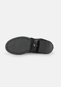 Černá bota s texturovanou gumovou podrážkou, koženým svrškem, plochým designem a bočním popruhem se zaobleným knoflíkovým uzávěrem.