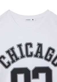 T-shirt bianco in cotone con scollatura rotonda, con la scritta "CHICAGO" in nero grassetto e il numero "02" sotto di essa. Tag della taglia visibile come "S."