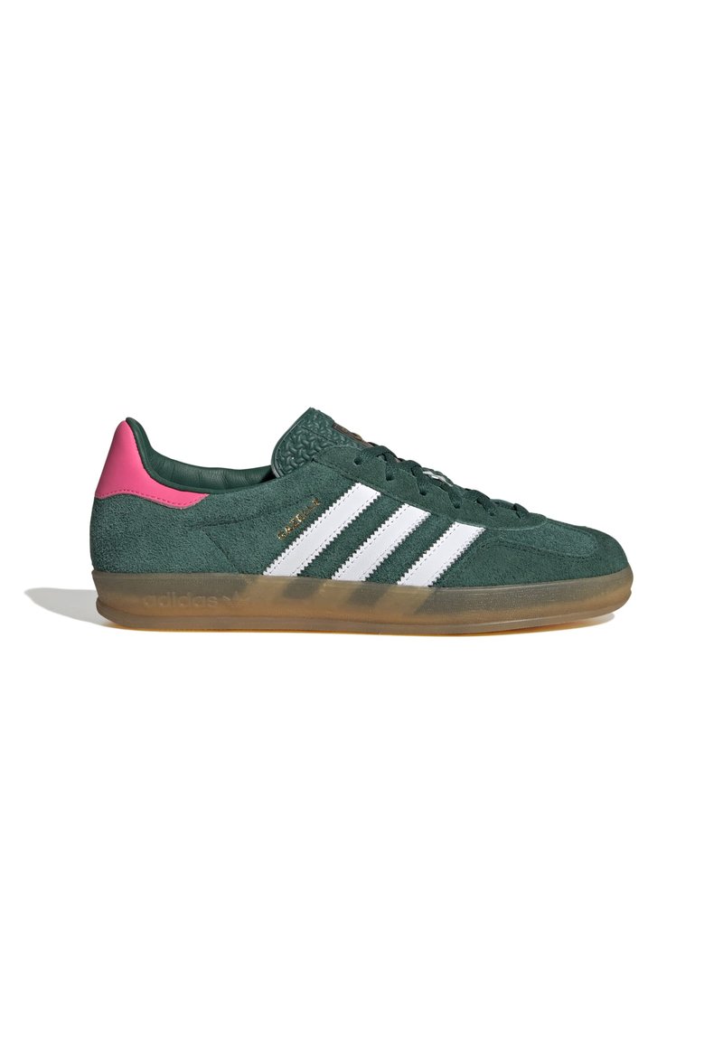 Sneaker verde in suede con strisce bianche, dettagli rosa sul tallone e suola in gomma. Presenta dettagli testurizzati sulla linguetta.