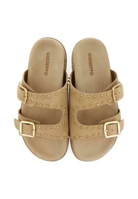 Sandali in suede beige con doppie fibbie e borchie dorate lungo le cinghie. Design open-toe e senza schiena per facilità d'uso, con una soletta testurizzata.