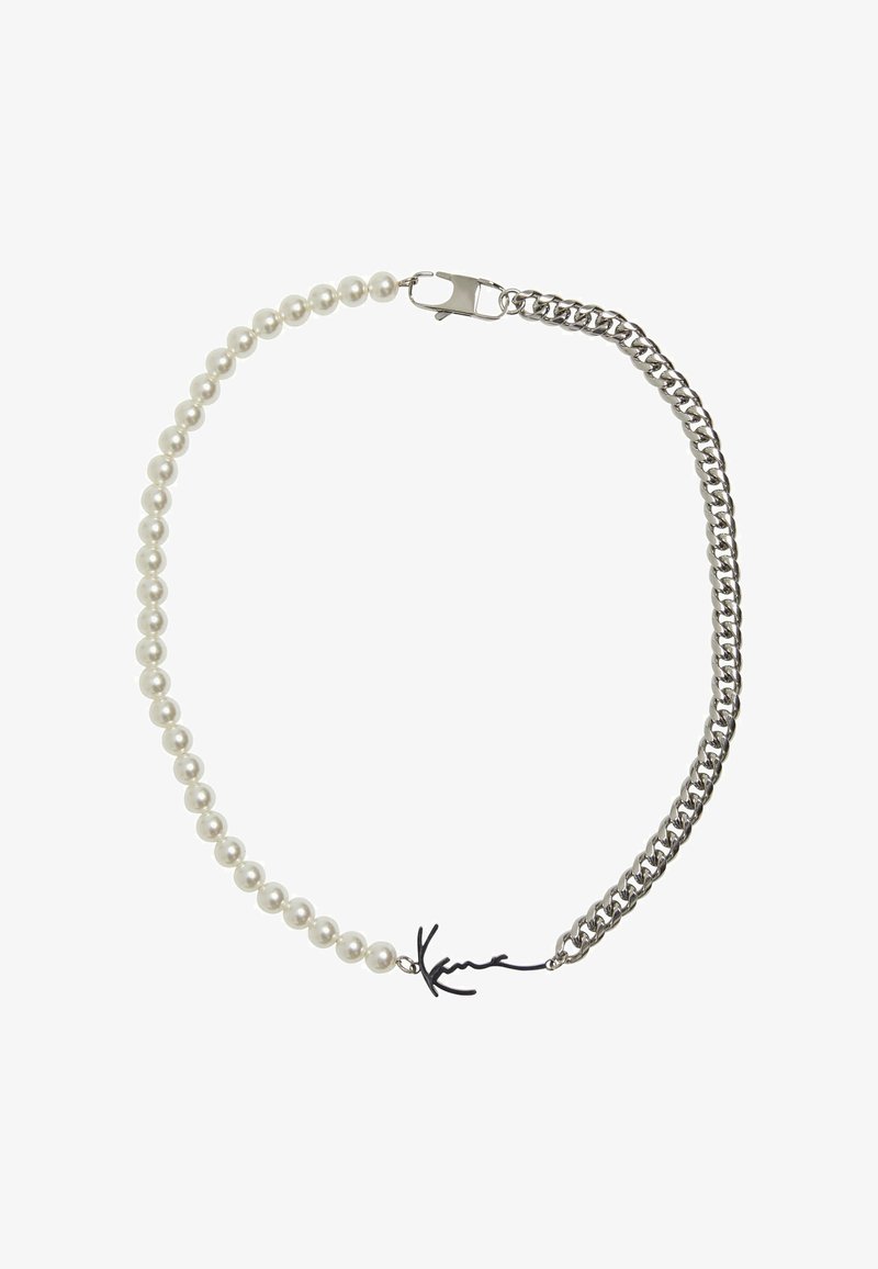 Pērļu kaklarota, kurā ir baltas sfēriskas pērlītes un daļa no savienotas sudraba ķēdes, ar melnu paraksta akcentu kā aizdari.