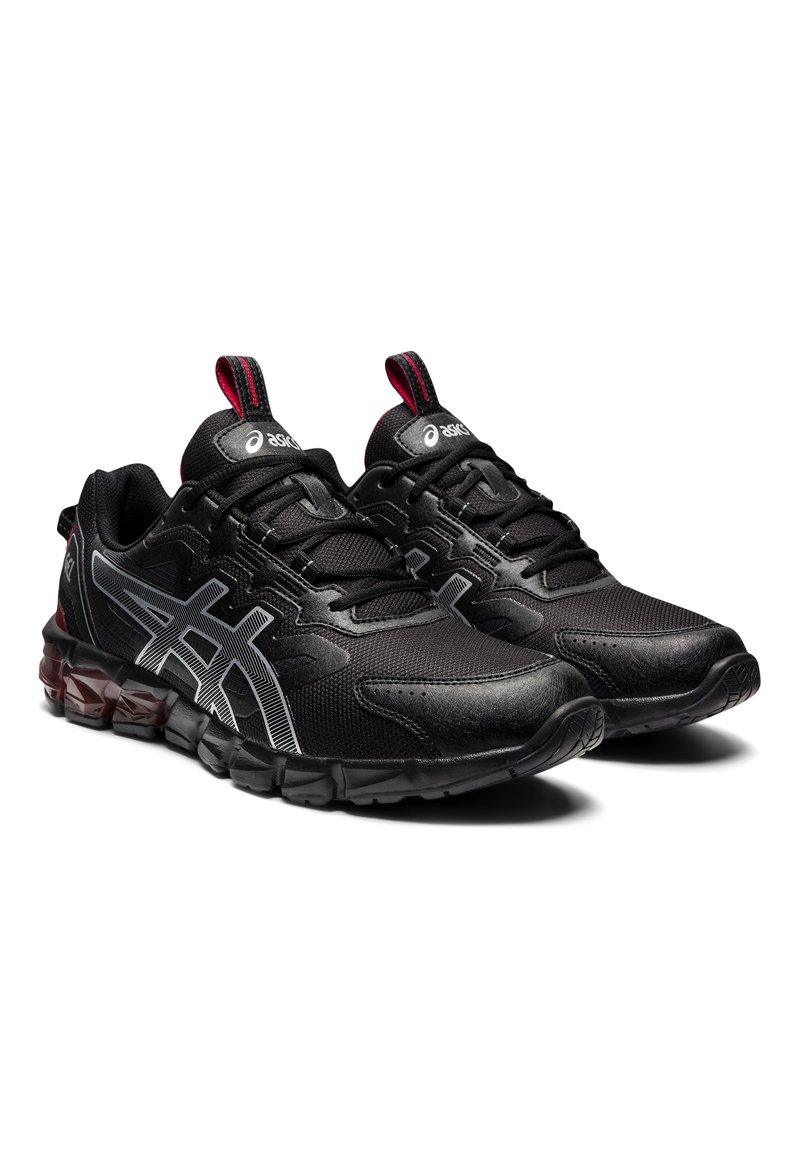 Scarpe da ginnastica nere con materiale in rete, dettagli testurizzati, logo riflettente argentato, linguetta rossa e un design della suola ammortizzata.
