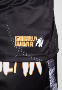 Zwarte sport shorts met een glanzende textuur, voorzien van een gedurfde "GORILLA WEAR"-logo in het geel en een grafisch ontwerp met witte en oranje accenten.