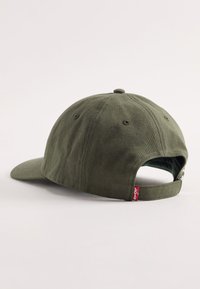 Donkergroen katoenen pet met een gebogen klep, verstelbare riem aan de achterkant en een klein rood Levi's label aan de zijkant.