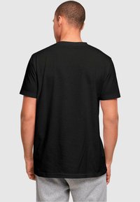 Black short-sleeve t-shirt, cotton material, crew neck design, smooth texture, relaxed fit. Visible stitching at shoulder and hem.