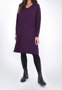 Lila knälång tröjklänning med V-ringning, lång ärm och avslappnad passform, i kombination med svarta ankelboots med nitar.