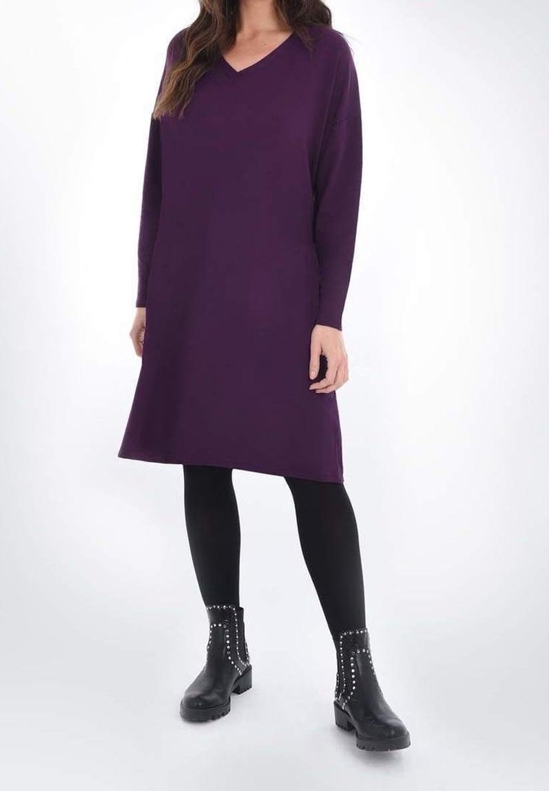 Lila knälång tröjklänning med V-ringning, lång ärm och avslappnad passform, i kombination med svarta ankelboots med nitar.