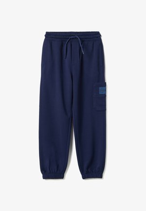 Pantalon de jogging bleu marine avec taille élastique, cordon de serrage, poches latérales, poche cargo avec écusson, et bords élastiques aux chevilles.