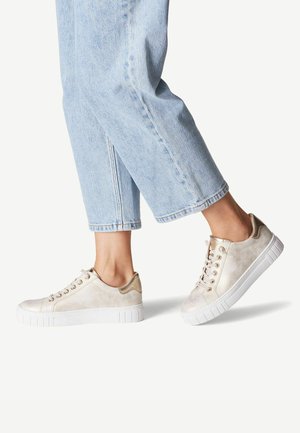 Kremfarvede sneakers med metalliske guld accenter, hvid gummisål og rund tå. Med snøring med guldfarvede øjer og en glat overflade.