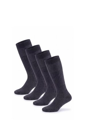 Vier Paare schwarzer, gerippter knielanger Socken, diagonal auf weißem Hintergrund angeordnet.