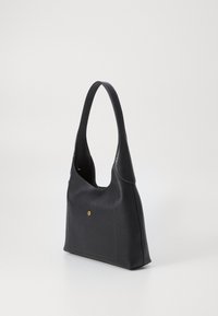Black leather handbag with a curved handle, smooth texture, rectangular shape, and a gold dot detail on the front.