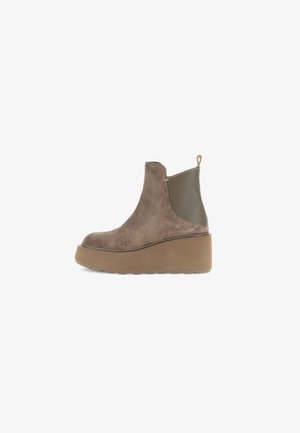 Stivaletti in suede marrone con punta rotonda, dettagli verde oliva e suola platform spessa. Presentano un inserto sul retro per indossarli facilmente.