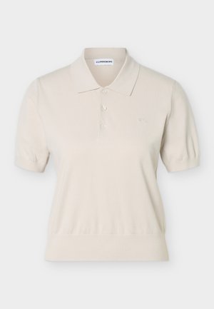 Beež lühikeste varrukatega polo särk, millel on kolm nuppu, sooniline ääreliist ja varrukad ning väike tikandiga logo rinnal.