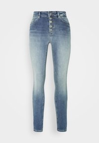 Jeans skinny de cintura alta en un lavado azul degradado. Cuenta con cierre de cinco botones, presillas para cinturón y una textura de denim suave.