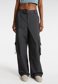 Pantaloni cargo grigi con gambe larghe, tessuto testurizzato, cintura regolabile e numerose tasche laterali con cerniere e lacci.