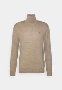 Pull à col roulé beige à manches longues avec un petit logo foncé brodé sur le côté gauche de la poitrine, présenté sur un fond blanc.