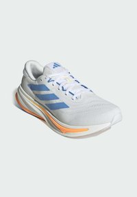 Zapatilla de running blanca con rayas azules, suela acentuada en naranja, cordones blancos y parte superior de malla, en ángulo para mostrar vistas lateral y superior.
