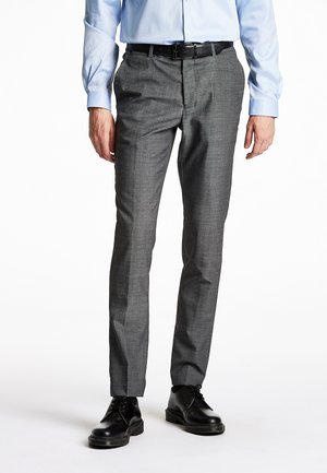 Grijze op maat gemaakte broek met een subtiel ruitpatroon, slim fit en een gladde stof; gecombineerd met zwarte veterschoenen en een lichtblauwe shirt.