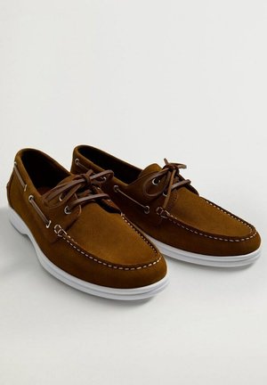Brązowe mokasyny zamszowe z białym przeszyciem i białymi gumowymi podeszwami, wyposażone w skórzane sznurówki przeplecione przez metalowe oczka.