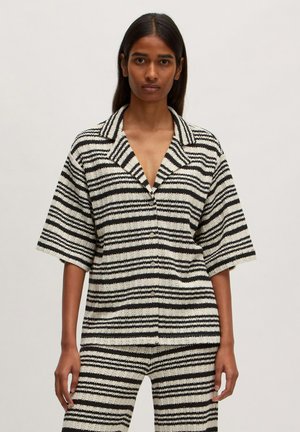 Striped two-piece set in black and cream with short sleeves, collar, and button closure; textured fabric with a woven pattern.