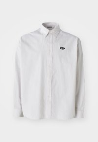 Camicia bianca a maniche lunghe con sottili righe verticali grigie. Presenta un colletto button-down e un piccolo logo nero sul lato sinistro del petto.
