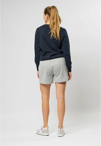 Marinblå sweatshirt med grå shorts. Sweatshirten har långa ärmar och ribbade ärmslut. Shortsen är knälånga, i mjukt tyg och med elastisk midja.