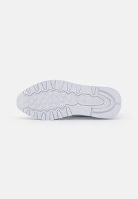 Reebok Sneaker-Sohle aus weißem Gummi. Merkmale sind ein kreisförmiges Grip-Muster und strukturierte Linien für Traktion. Logo in der Nähe der Mitte geprägt.