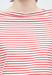 Czerwono-biała bluzka w paski z szerokim dekoltem, lekkiego materiału i luźnym kroju. Paski są równomiernie rozmieszczone i poziome.