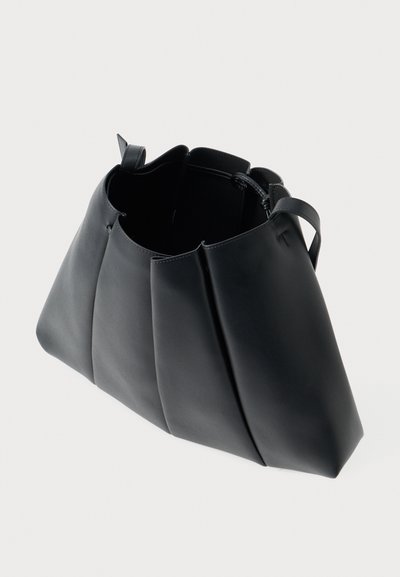 Geantă tote din piele neagră, cu o formă structurată, având părți pliate și un interior spațios. Mânere scurte pentru transport.