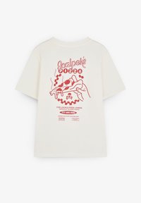Hvid t-shirt med rød grafik af en hånd, der holder en pizzastykke, tekst "Scalpel's Pizza," telefonnummer, og to adresseinformationer på bagsiden.