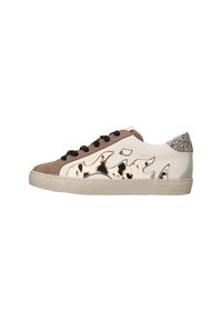 Zapatilla baja con paneles beige y marrón claro, cordones negros, diseño de estampado de vaca en los laterales y detalle de talón plateado brillante.