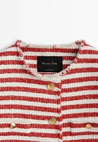 Haut en tissu texturé à rayures rouges et blanches avec un col effiloché, orné de boutons dorés et d'une étiquette noire portant l'inscription « Massimo Dutti ».