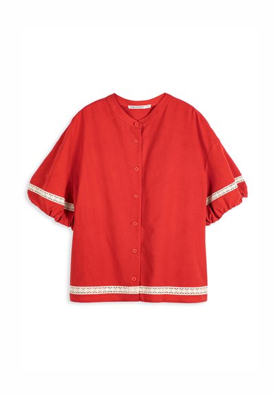 Chemisier rouge à manches courtes avec boutons sur le devant, col rond, manches bouffantes et bordure en dentelle blanche aux manches et à l'ourlet.