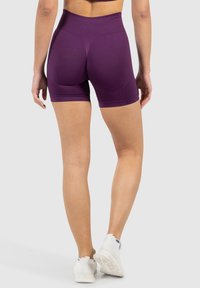 Pantalones cortos morados de talle alto, hechos de un tejido elástico, con un diseño ajustado y una textura suave, sin patrones ni herrajes visibles.