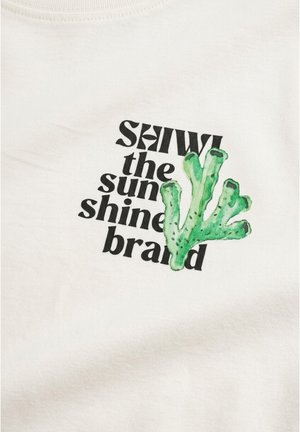 Biela látka s čiernym textom "SHIWI the sunshine brand" a zelenou ilustráciou koralu prekryvajúcou text.