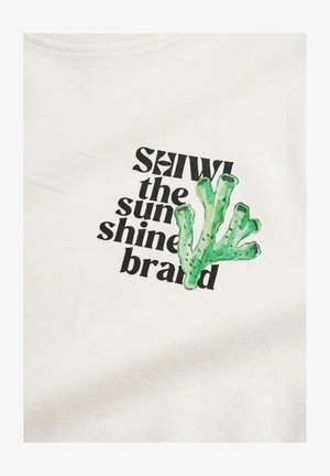 Valge kangas musta tekstiga "SHIWI päikesepaiste bränd" ja roheline korallillustratsioon, mis kattub tekstiga.