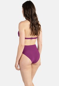 Bikini taille haute en violet foncé uni, avec un haut bandeau et une attache réglable dans le dos. Texture lisse, design simple et couverture minimale.